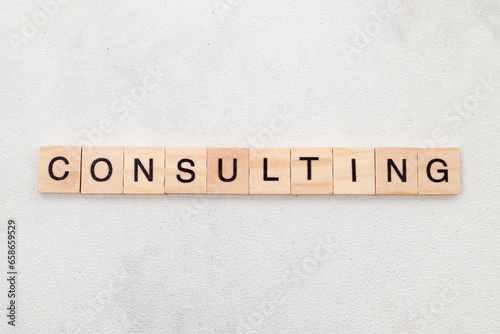 Top view of Consulting word on wooden cube letter block on white background. Business concept