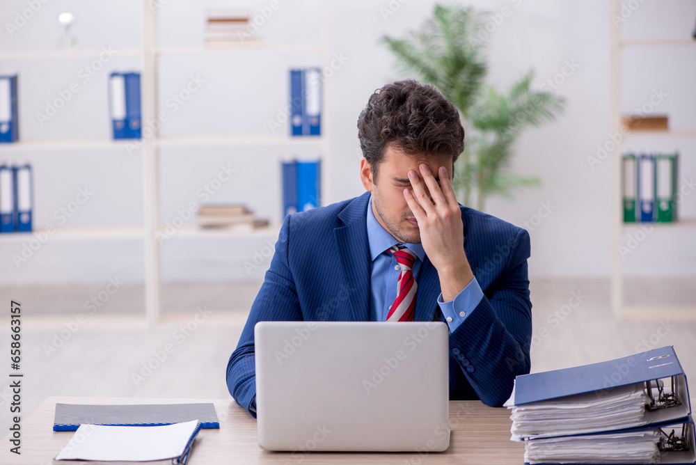 Young male employee working in the office Young male employee working in the office