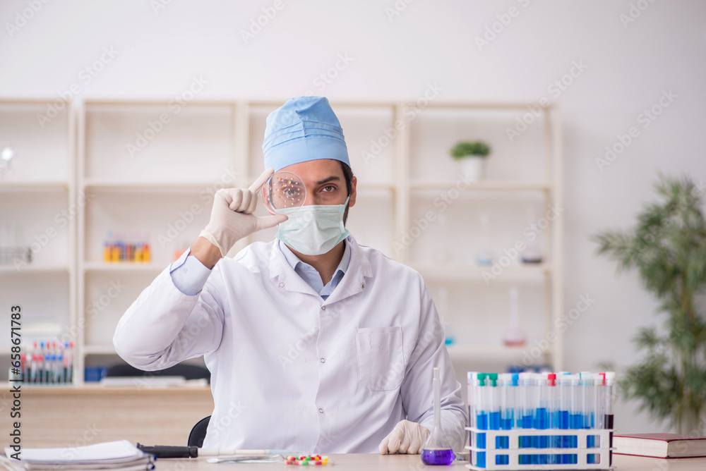 Fototapeta premium Young male chemist working at the lab