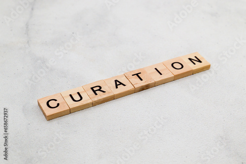 Top view of Curation word on wooden cube letter block on white background. Business concept