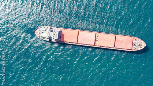 Aerial front view Container cargo ship full carrier container with terminal commercial port background for business logistics, import export, shipping or freight transportation.