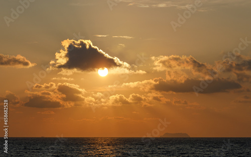 Beautiful tropical seascape sunset, with clouds and orange sky over the Andaman Sea, with Koh Phi Phi Leh (where the film The Beach was filmed) on the horizon.