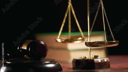 A judge is hitting gavel off a block in courtroom. Close up of scales of justice and legal lawyer books or codex. Sentence or win at auction. Law or legal system and jurisprudence or court concept.