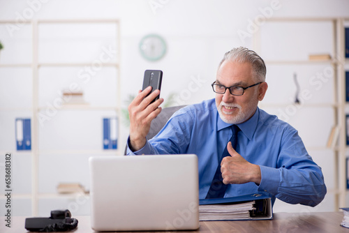 Old male employee working in the office