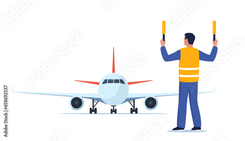 Aviation marshaller in uniform navigate with light sticks. Air traffic controller in signal vest at aircraft runway. Airplane landing. Airport crew. Standing man with sticks. Vector illustration. photo
