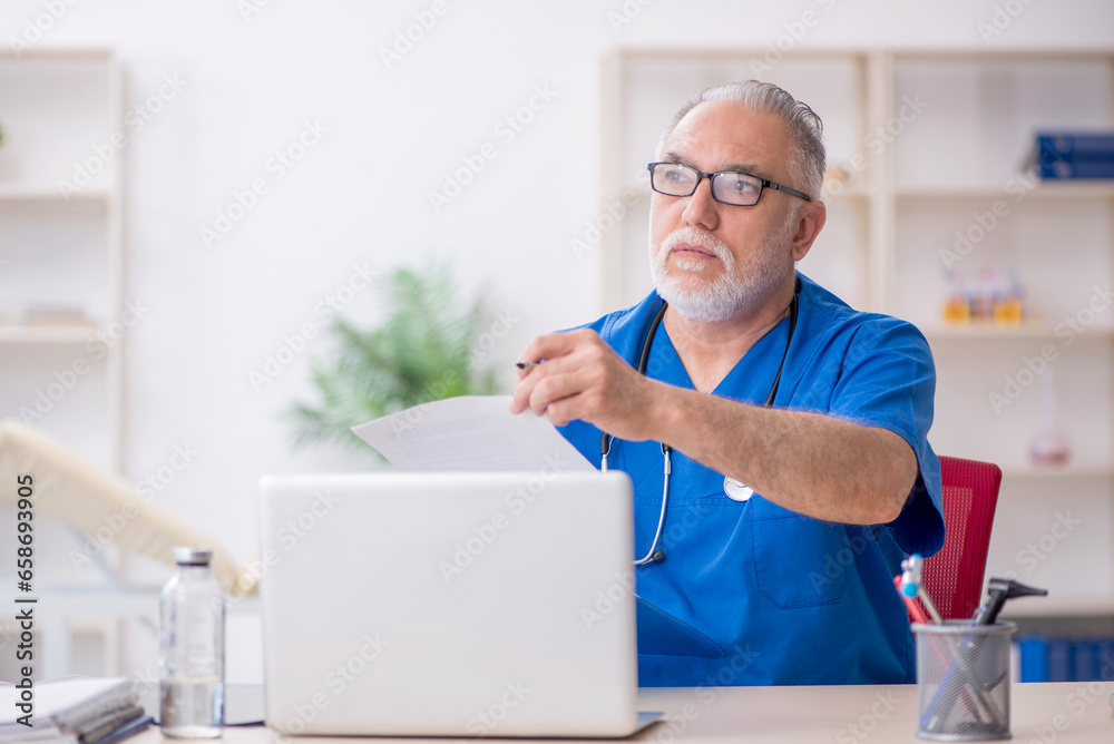 Old male doctor working in the clinic Old male doctor working in the clinic