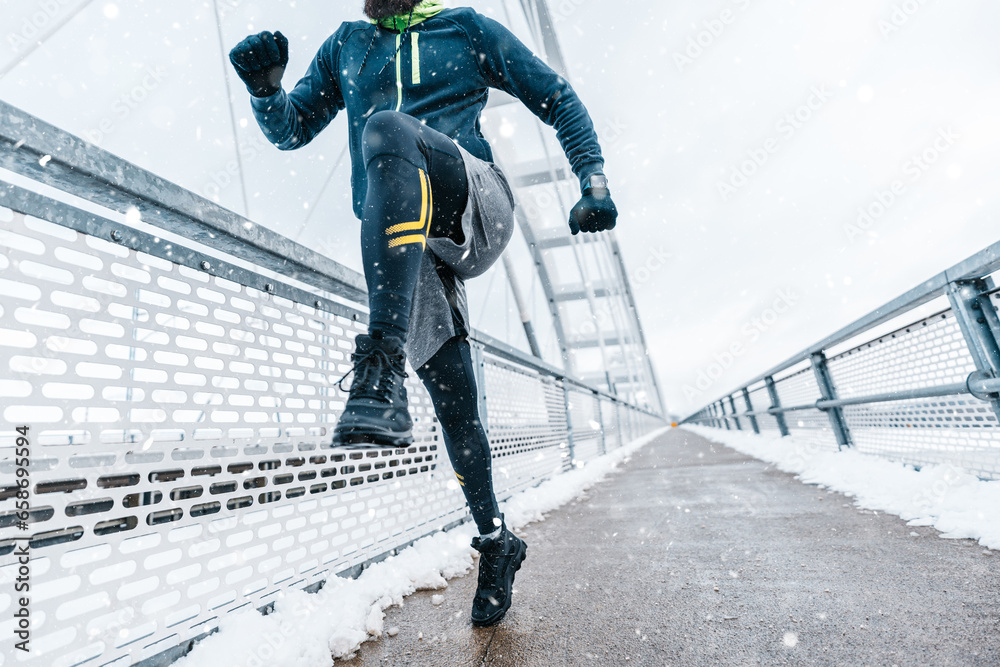 Obraz premium Handsome middle age man with a beard running and exercising outside on extremely cold and snowy day. Sport and fitness motivation theme.