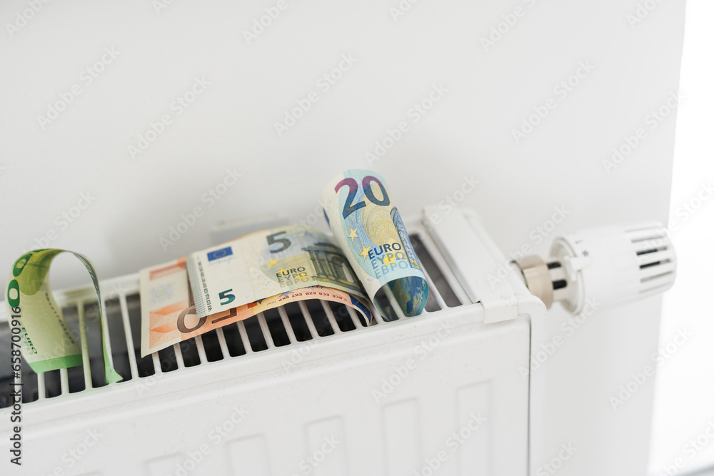  banknote lying on the radiator, the concept of rising energy prices and more expensive heating