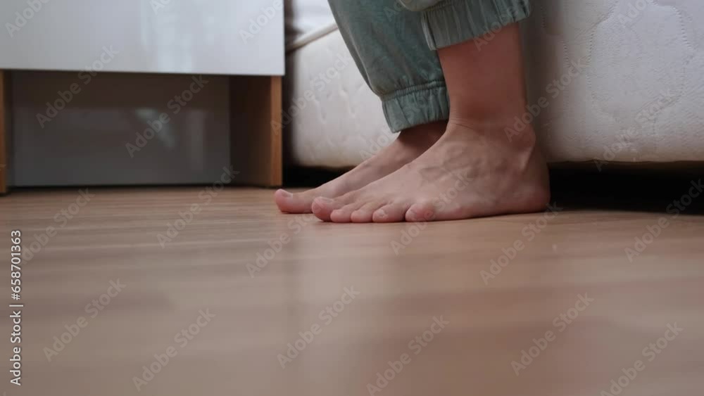 getting up in the morning. low section view of female feet standing on floor after waking up