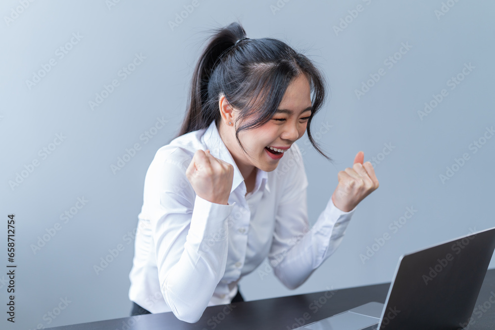 Portrait of a happy beautiful Asian businesswoman. Working with a laptop and Mobilphone in a company office Portrait of a happy beautiful Asian businesswoman. Working with a laptop and Mobilphone in a company office