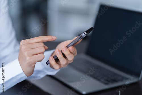 Asian businessman using laptop computer and smartphone contact business search information on desk in the office. checks mail, 