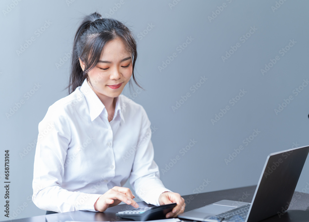 Portrait of a happy young Asian businesswoman celebrating success with arms raised in front of a laptop in the office, freelancer has finished a project. Portrait of a happy young Asian businesswoman celebrating success with arms raised in front of a laptop in the office, freelancer has finished a project.