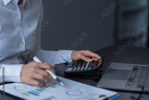 Asian businessman using laptop computer and smartphone contact business search information on desk in the office. checks mail  