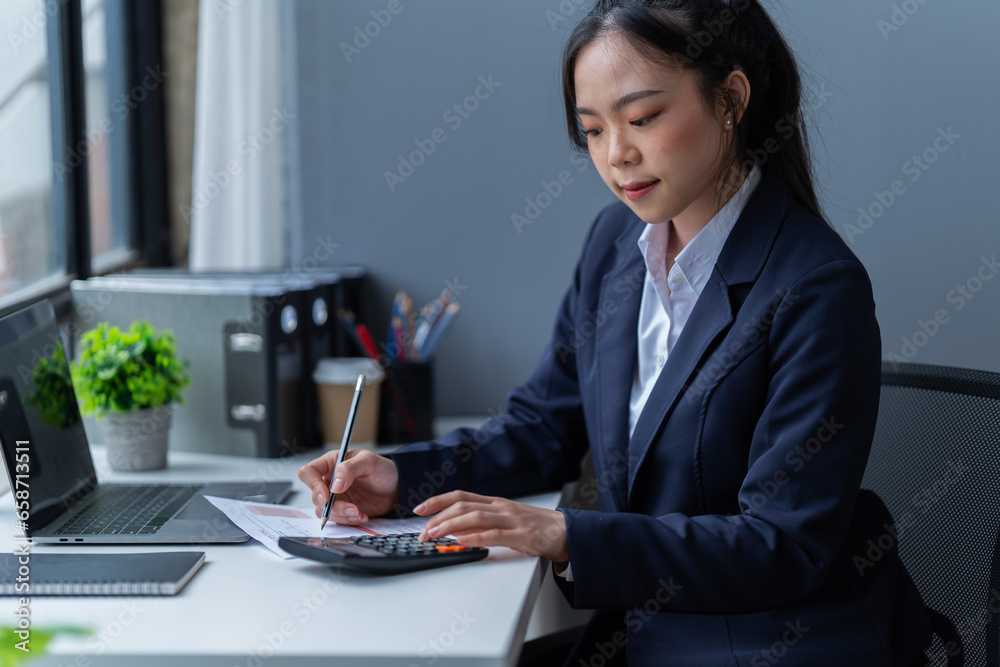 Smiling female student browsing laptop and tablet sitting at table holding coffee cup with papers and books while doing homework in cozy cafe Smiling female student browsing laptop and tablet sitting at table holding coffee cup with papers and books while doing homework in cozy cafe