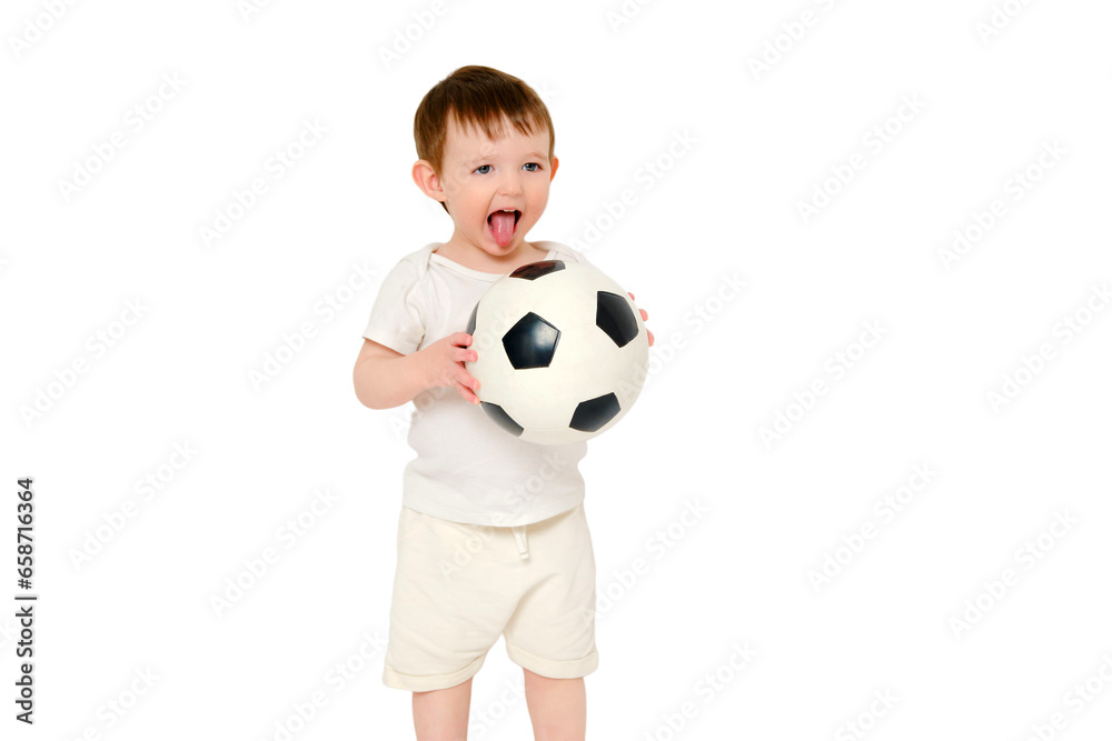 Happy baby holding a soccer ball on a studio, isolated on white background. Smiling child playing football, isolated on white background. Kid about two years old (one year nine months)