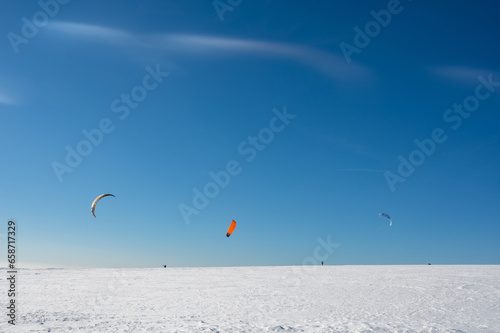 Kitesurfing in the snow with a blue sky