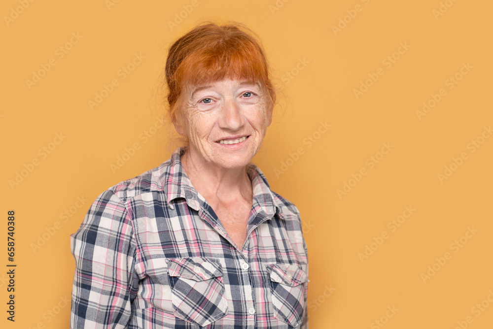 Happy senior woman smiling, dressed in simple work clothes, she likes to work and enjoy life. An elderly woman with red hair is smiling Happy senior woman smiling, dressed in simple work clothes, she likes to work and enjoy life. An elderly woman with red hair is smiling