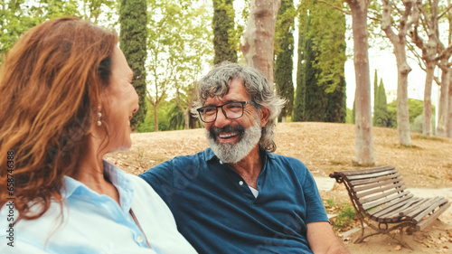 Loving couple talking while sitting outside in the park in autumn