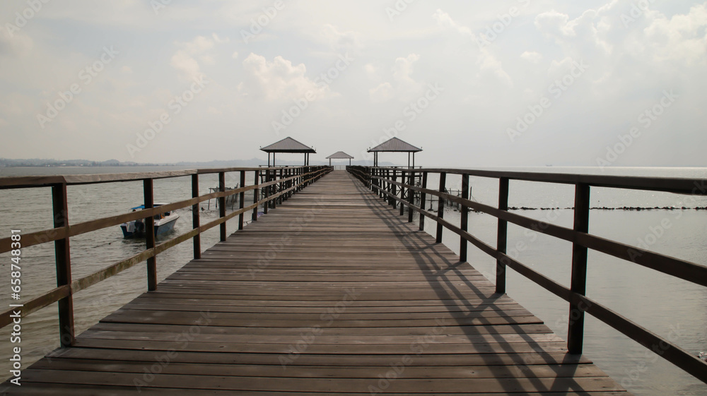 Wooden bridge dock or pier or boardwalk jetty for ship to dock at the shore.