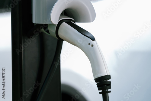 Closeup EV charging station with electric charger plug connected to charging platform power sauce. Alternative clean and sustainable energy for eco-friendly EV car for better future. Synchronos