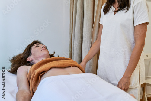 Traditional chinese medicine practitioner and patient talking during acupuncture fertility treatment photo