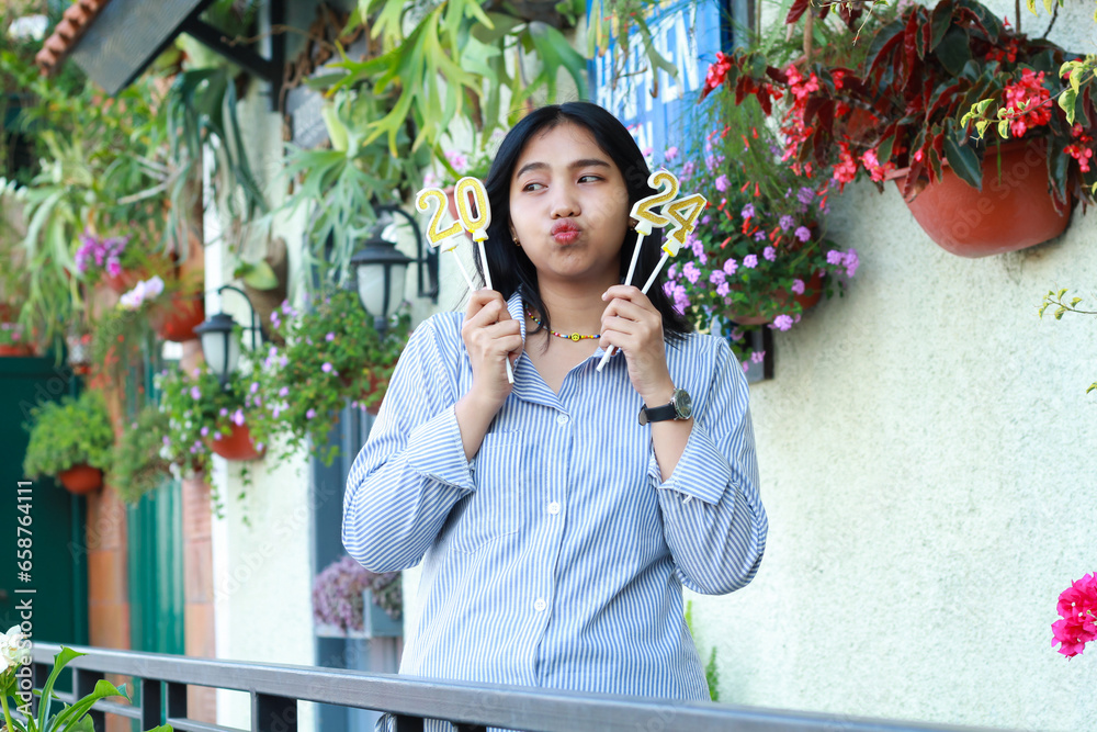 thoughtful asian young woman looking aside with kissing lips and holding 2024 number candle, beautiful female standing on railing of old house terrace garden, outdoor thoughtful asian young woman looking aside with kissing lips and holding 2024 number candle, beautiful female standing on railing of old house terrace garden, outdoor