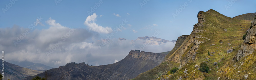 Russia. The Elbrus region. The high mountain peaks of the North Caucasus are surrounded by morning misty clouds hovering at different levels of inaccessible rocks. Russia. The Elbrus region. The high mountain peaks of the North Caucasus are surrounded by morning misty clouds hovering at different levels of inaccessible rocks.