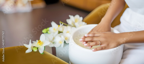 A woman's hand receiving a natural and elegant manicure treatment at a spa or salon, showcasing the meticulous care and attention to detail.