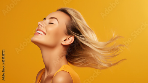 Confident mature woman with crossed arms in casual clothing with copy space. Successful smiling woman with big grin looking at camera. Beautiful positive businesswoman standing against yellow
