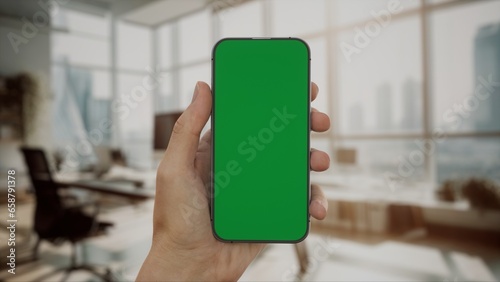 CU 30s Caucasian male holding a phone in vertical orientation, green screen