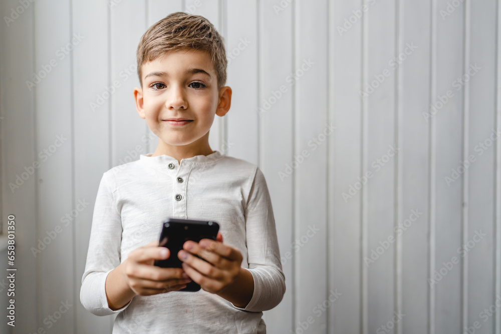 One caucasian boy child use smartphone mobile phone at home play games One caucasian boy child use smartphone mobile phone at home play games