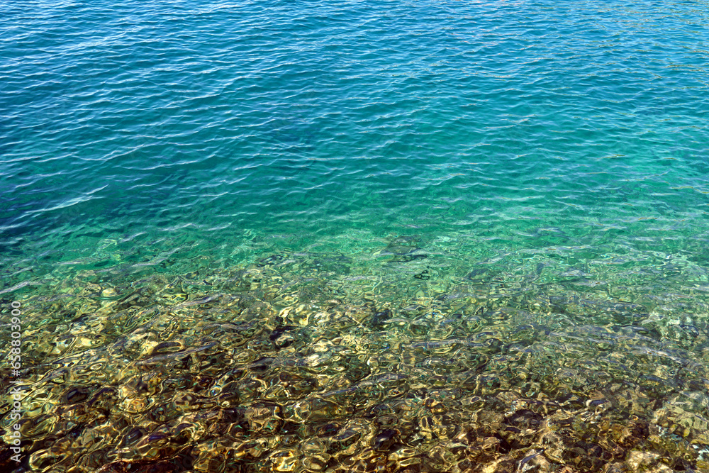 Obraz premium Transparent shallow sea with pebbles under the surface