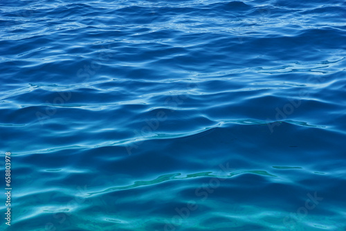 Gradient blue and turquoise colors of wavy blue deep sea water © Happy window