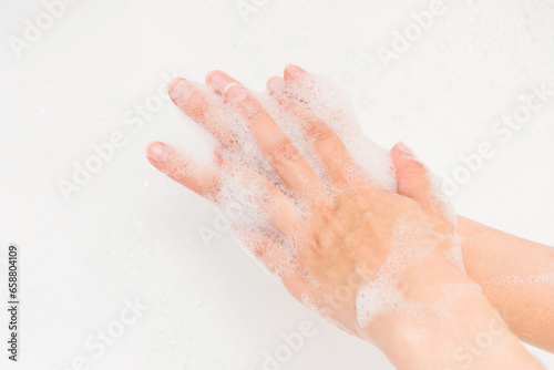 Foam soap on woman hand close up view. Skincare washing hand. Bath relaxing time.