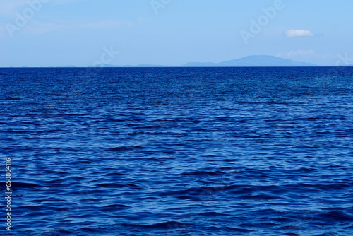 Far sea horizon with moody sky and wavy sea surface