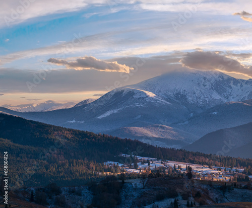 Late autumn mountain pre sunset scene with snow covered tops in far. Picturesque traveling  seasonal  nature and countryside beauty concept scene. Carpathians  Ukraine.