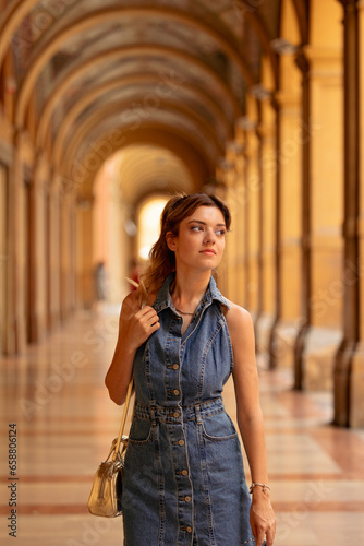 A young woman walking along the Portici di Bologna, Italy.