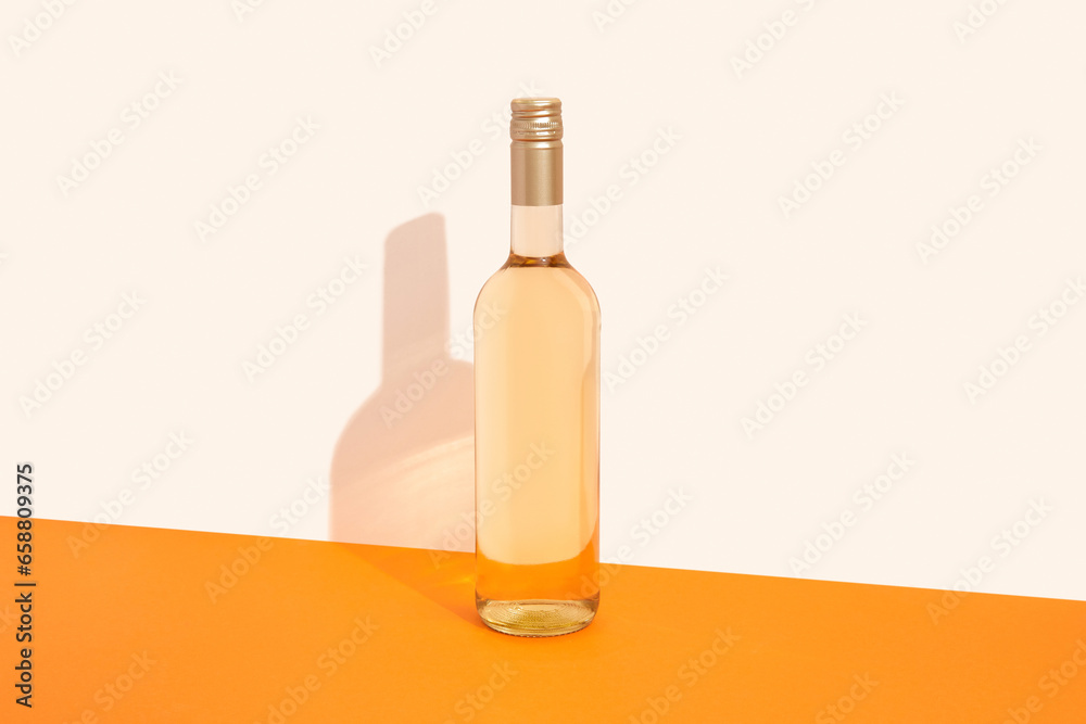 Bottle of white wine on orange background with deep shadows. Mock up drink with place for you lable and text Bottle of white wine on orange background with deep shadows. Mock up drink with place for you lable and text