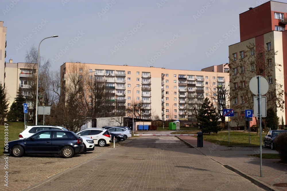 Fototapeta premium A housing estate with blocks of flats built in the 1980s by the access road with parked cars in Poland