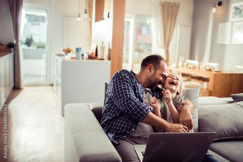 Young Caucasian father and daughter using a laptop at home Young Caucasian father and daughter using a laptop at home