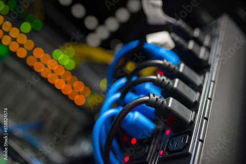 Plugged IEC 60320 C14 power cables to IEC 60320 C13 sockets in a server rack.