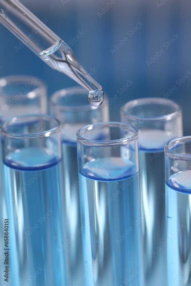 Dripping reagent into test tube on blurred background, closeup. Laboratory analysis Dripping reagent into test tube on blurred background, closeup. Laboratory analysis