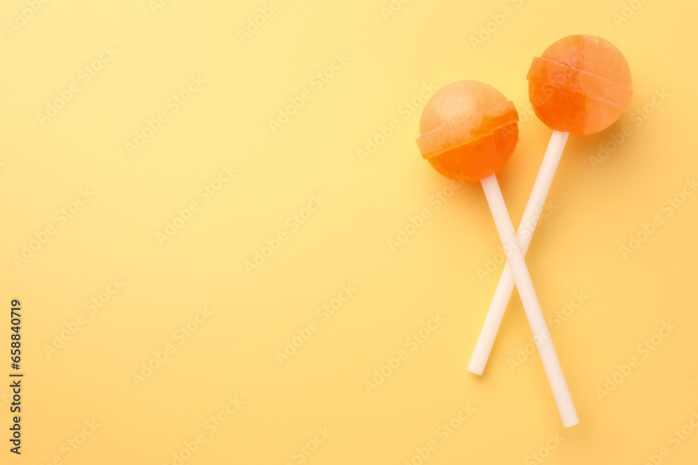 Tasty lollipops on yellow background, flat lay. Space for text Tasty lollipops on yellow background, flat lay. Space for text