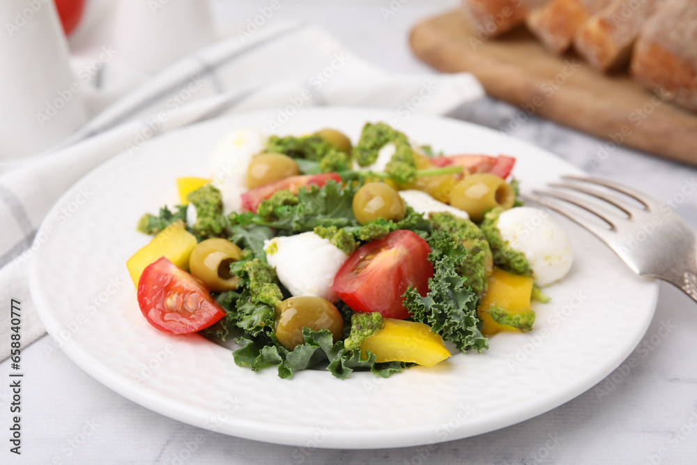 Delicious salad with pesto sauce and fork on white table, closeup