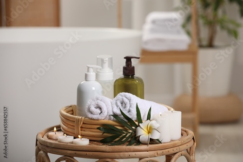 Spa products  burning candles  plumeria flower and tropical leaf on table in bathroom