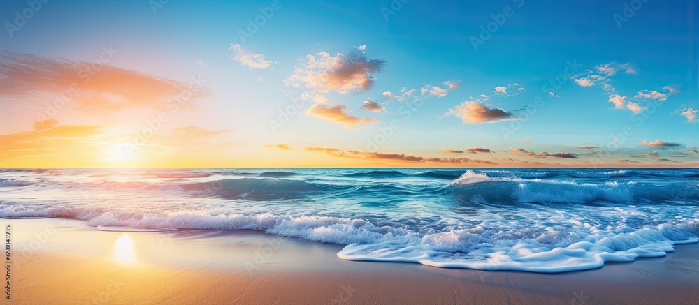 Vibrant dawn at the beach with blue sky and sunbeams With copyspace for text - obrazy, fototapety, plakaty 