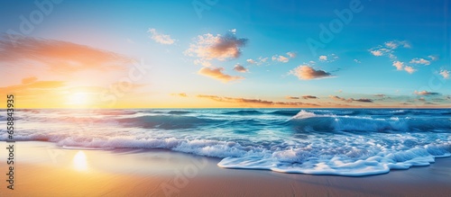 Vibrant dawn at the beach with blue sky and sunbeams With copyspace for text