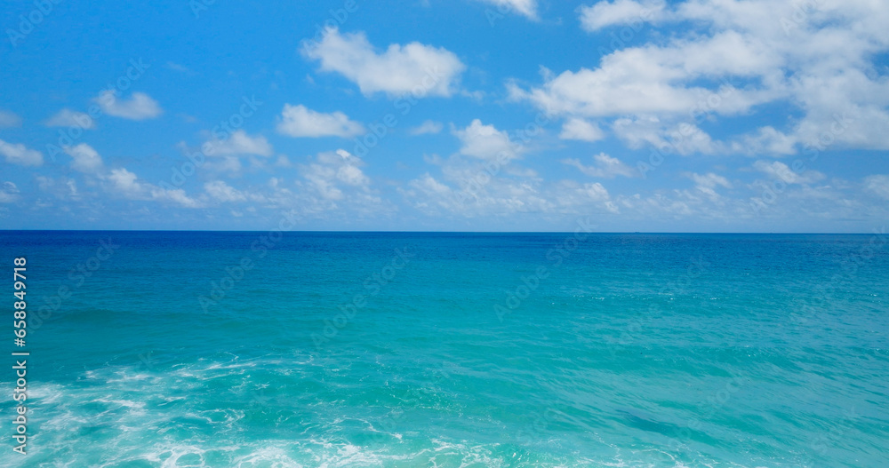 4K Aerial view Blue sky with white clouds moving panorama summer. Sea in light of day aerial view of drone slide forward. Small waves on sea. Sunny sunny over the sea. 4K Aerial view Blue sky with white clouds moving panorama summer. Sea in light of day aerial view of drone slide forward. Small waves on sea. Sunny sunny over the sea.