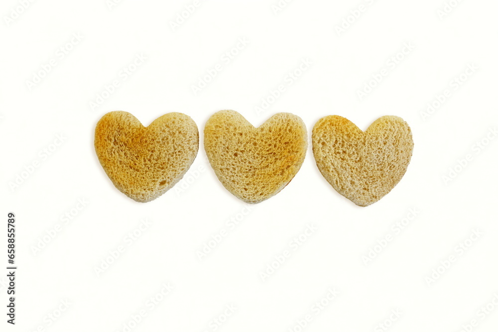 Fototapeta premium group of Roasted cut out heart shaped slice of toast bread in white background,copy space
