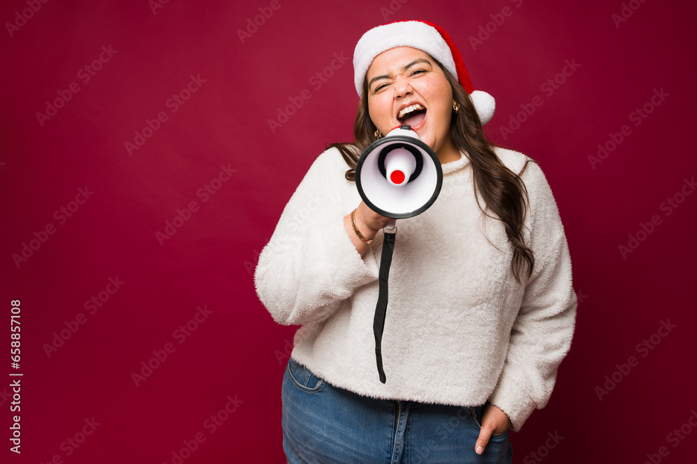 Fototapeta premium Happy obese woman screaming with a megaphone for christmas